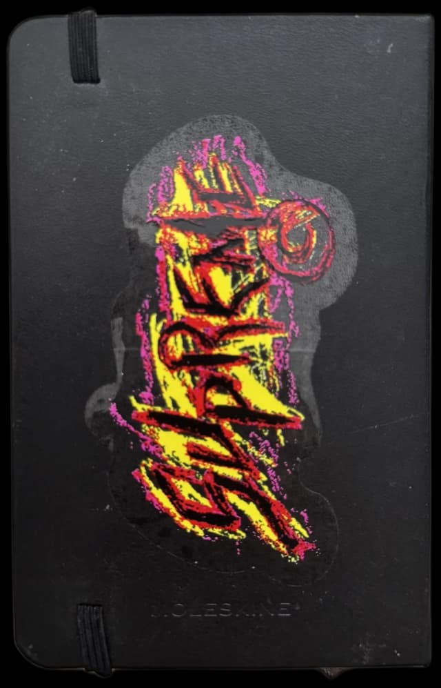 black sketchbook with a hand-drawn graffiti sticker cover